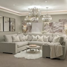 a living room filled with furniture and a chandelier hanging above the couches