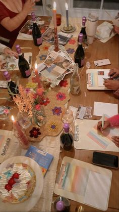 people sitting at a table with many cards and candles on top of it, all decorated in different colors