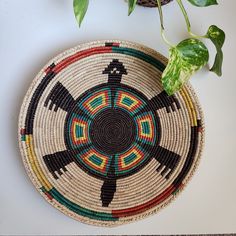 a woven basket sitting on top of a white table next to a potted plant