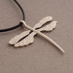 "Attract all the right attention with this dragonfly pendant, made of sterling silver 925. Hangs on 42 cm cord (16 1/2\") with silver clasp and endings. A hammered piece, perfectly conveys the exquisite, organic beauty found in nature. Pendant measures 3.5 cm x 2.7 cm (1.38 inches x 1.06 inches) Metal: Sterling silver 925, slightly oxidized for a more vivid look. If you want a different cord length, write us the desirable length to the \"note to the seller\" during the checkout process. If you p Adjustable Sterling Silver Dragonfly Necklace, Dragonfly Jewelry Necklace, Silver Dragonfly Necklace, Dragonfly Jewelry, Dragonfly Necklace, Dragonfly Pendant, Organic Beauty, Bridesmaid Gifts, Charm Necklace