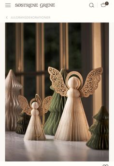 three wooden angel figurines sitting next to each other on top of a table