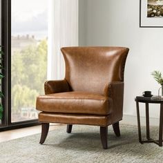 a brown leather chair sitting in front of a window