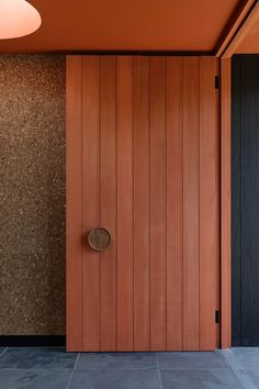 an orange door in front of a wooden wall