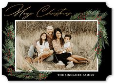 a christmas card with an image of two adults and one child sitting in the grass