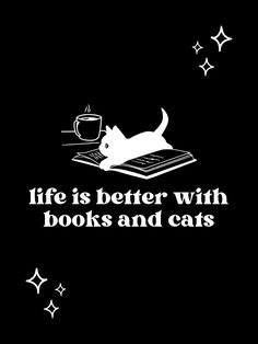 a white cat laying on top of a book next to a coffee cup and stars