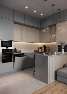 a modern kitchen with an island in the middle and two pendant lights hanging from the ceiling