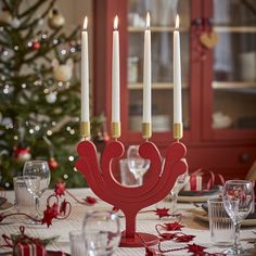 candles are lit on a table with red and white decorations