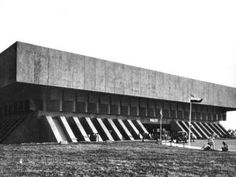 an old black and white photo of the exterior of a building with stairs leading up to it