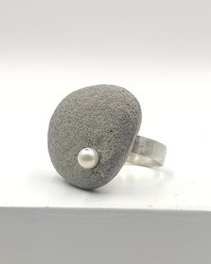 Concrete ring 925 Sterling Silver for women. A handcrafted ring made with 925 Sterling Silver and adorned with one asymmetric concrete charm, adorned with one white freshwater pearl!  A statement ring for appearances to be discussed! Freshwater pearl is June's birthstone! In contact with skin, moisture and air, concrete becomes darker. Αs each piece is individually handmade, slight variations in  texture are possible. DESCRIPTIONS and MEASUREMENTS: Material:sterling silver . Material: Concrete ,freshwater pearl. Dimensions concrete: 2,6*3,3cm 1,023*1,29 Size ring in photo: 7,5 USA size SEE MORE CONCRETE JEWELRY HERE: www.etsy.com/shop/ArtisJewels?ref=seller-platform-mcnav§ion_id=36353295 Visit my Etsy shop, ArtisJewels, to see more rings and jewelry and other unique handmade pieces. www.et Concrete Ring, Architectural Jewelry, Concrete Jewelry, Square Rings, Handcrafted Rings, White Freshwater Pearl, Silver Material, June Birth Stone, Silver Band