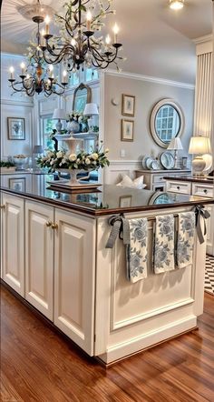 a kitchen island with towels hanging on it's side and a chandelier in the background