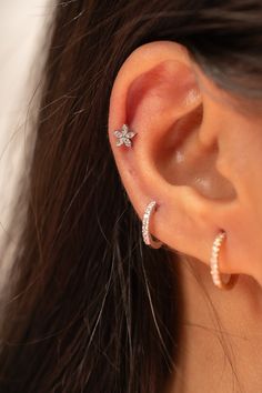 a woman's ear is shown with three small stars on the top and bottom