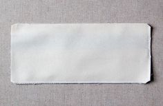 a piece of white cloth on top of a gray surface with a small hole in the middle