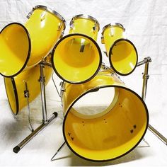 a yellow drum set sitting on top of a white sheet