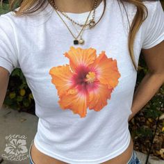 Hibiscus Orange Flower Graphic Baby Tee  💕 ABOUT - The same baby-tee fit you know & love! - Super comfortable and soft material. - 100% sustainably sourced ring-spun cotton, coloured with OEKO-TEX certified low-impact dyes. - All t-shirts come with pearlized, tear-away labels for total comfort and a scratch-free experience. 🌟SIZING - Please find the size chart in the description before purchasing. 💖CARE/ WASH - Machine wash: warm 30C (max 40C or 105F) - Non-chlorine bleach as needed - Tumble Flower Top Aesthetic, T Shirt Design Flower, Hibiscus T Shirt, Hibiscus Clothes, Hibiscus Outfit, Hibiscus Clothing, Graphic Tees Design Prints, Tee Shirt Ideas, Aesthetic Graphic Tees