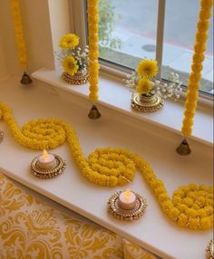 a window sill decorated with yellow flowers and candles for diwaling on the windowsill