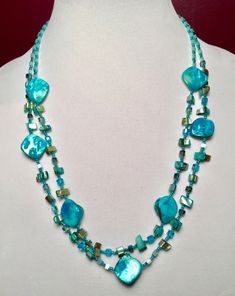 These double strand necklaces are made with seed beads, square cut crystal beads, shell beads, and mother-of-pearl beads. The color is outstanding and vibrant like the ocean itself. The shell beads have an iridescent shimmer to them and the crystal beads give added sparkle. It is finished off with a shell clasp.  If you love teal or turquoise color and love the beach then this necklace is for you! Blue Double Strand Beaded Pearl Necklace, Multi-strand Mother Of Pearl Beaded Necklaces, Beaded Shell Necklace With Mother Of Pearl Round Beads, Beaded Shell Necklace With Round Mother Of Pearl Beads, Beaded Mother Of Pearl Shell Necklace With Round Beads, Beaded Multi-strand Mother Of Pearl Jewelry, Multi-strand Beaded Mother Of Pearl Necklace, Multi-strand Beaded Mother Of Pearl Jewelry, Multi-strand Mother Of Pearl Beaded Necklace