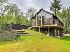 a large house sitting on top of a lush green hillside