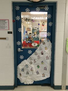 a door decorated with snowflakes and paper machs for the winter holidays in an elementary classroom