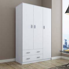 a white cabinet in a room with a lamp on the floor and a window behind it