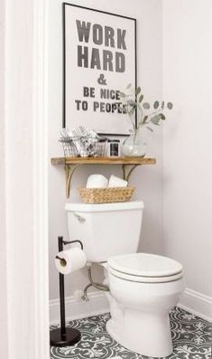 a white toilet sitting in a bathroom next to a wooden shelf