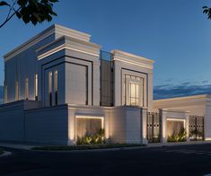 a large white building sitting on the side of a road at night with lit up windows