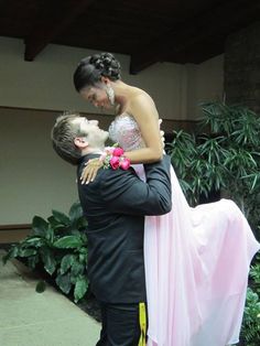 a man in a tuxedo is holding a woman