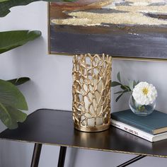 there is a vase with flowers on the table next to some books and a plant