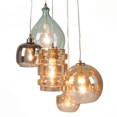 three glass lamps hanging from the ceiling with lights attached to them and one light on each side