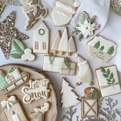 some cookies are laying on a table with decorations and other items around them that say let it snow