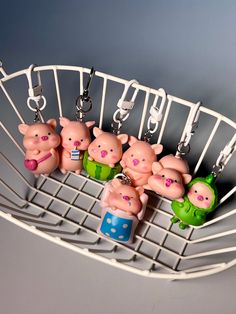 five little pig keychains hanging from a rack