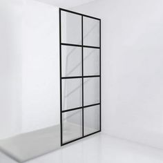 an empty room with white walls and black window frames on the wall, in front of a mirror