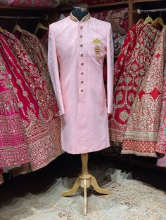 This taupe pink simple perfect attire for his perfect wedding event. This exquisite sherwani is enriched in zardozi, stones & thread on the mandarin collar and the designer buttons are rightly sufficing the attire. Available with matching chudidar. Size: 42, 44, 46 Ready to Ship! Pink Long Sets With Intricate Embroidery, Long Pink Sets With Intricate Embroidery, Pink Sets With Intricate Embroidery, Pink Sherwani With Intricate Embroidery, Pink Raw Silk Sherwani With Traditional Drape, Pink Bandhgala With Resham Embroidery For Eid, Bollywood Wedding Sherwani With Dori Work, Wedding Bollywood Sherwani With Dori Work, Pink Sherwani With Zari Work For Festivals