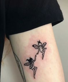 a woman with a small tattoo on her arm that has three little fairy tattoos on it