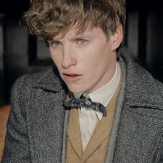 a young man wearing a suit and bow tie