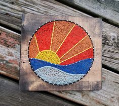 a piece of art that has been made to look like a sun on a wooden surface