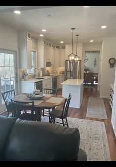 a kitchen and living room are separated by an open floor plan, while the dining area is adjacent to the kitchen