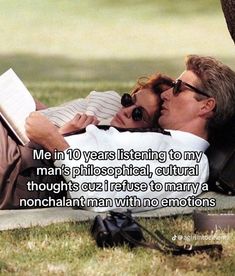 a man and woman laying on the grass with a book in their lap, kissing