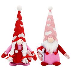 two stuffed gnomes are standing next to each other with hearts on their hats and tails