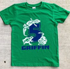 "This personalized Reptile Birthday shirt can come with any name and age you want, I can do just name, age or graphic too, leave your specifications in the notes at checkout. There are many different choices for the shirt color and the graphic color. Look through the listing photos for your options. Please look carefully at the size chart and measure it against a well fitting shirt of your own. These are short sleeve tshirts. They can also be done on either a long sleeve shirt or a raglan (baseb Green T-shirt With Dinosaur Print For Birthday, Customizable Green T-shirt For Birthday, Playful Green T-shirt For Birthday, Green Custom Print T-shirt For Birthday, Green Dinosaur Print T-shirt For Birthday, Fun Green T-shirt For Birthday, Green Custom Print Birthday T-shirt, Green Crew Neck Birthday Shirt, Green Fun Birthday T-shirt