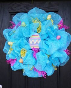 a blue mesh wreath with an easter egg on it's front door hanger