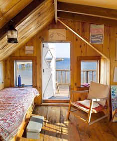 a bedroom with wooden walls and flooring next to the ocean