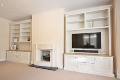 an empty living room with a fireplace and entertainment center