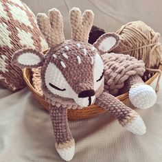 a knitted stuffed animal laying in a basket