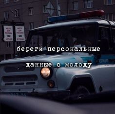 a police car driving down a street next to tall buildings with words written on the front