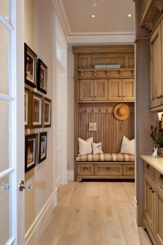 an image of a hallway with wooden cabinets and pictures on the wall in front of it