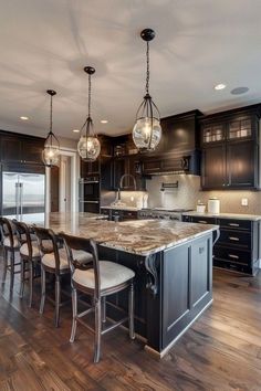 a large kitchen with wooden floors and black cabinets