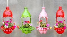 four different colored bird feeders with flowers in them