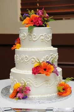 a wedding cake decorated with flowers on a table