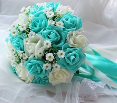 a bridal bouquet with blue and white flowers on it, sitting on a bed