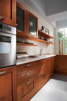 a modern kitchen with wooden cabinets and stainless steel appliance on the countertop